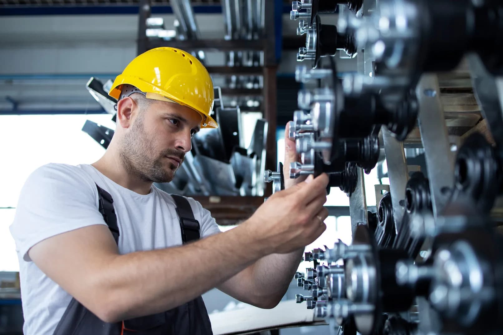 A technician in a hard hat working on machinery